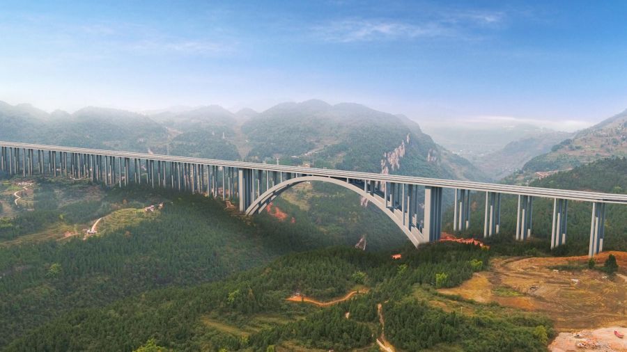古金高速水落河特大橋，全長(zhǎng)1701米，為上承式鋼筋混凝土懸臂澆筑拱橋，跨徑335米，超過(guò)世界已知同類(lèi)型最大跨徑拱橋---美國(guó)胡佛水壩大橋332m的跨徑，穩(wěn)居世界第一。該橋首創(chuàng)數(shù)字化智能橋梁建設(shè)、管理、施工作業(yè)體系，在結(jié)構(gòu)上為大跨度混凝土拱橋的設(shè)計(jì)提供基礎(chǔ)和參考，為山區(qū)寬幅薄壁箱型拱橋的懸臂施工提供技術(shù)經(jīng)驗(yàn)。.jpg